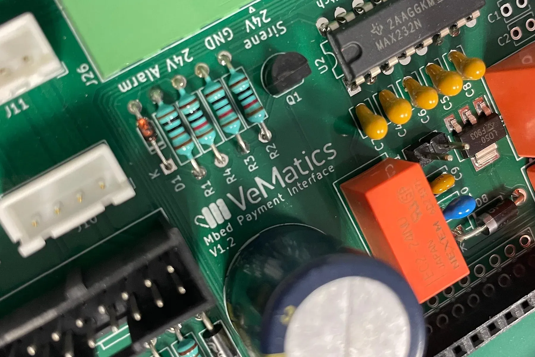 Close-up van een VeMatics-besturingsprint, met de VeMatics-opdruk naast weerstanden, een relais en connectoren